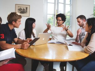 Studenten vieler Nationen sitzen um einen Tisch herum.